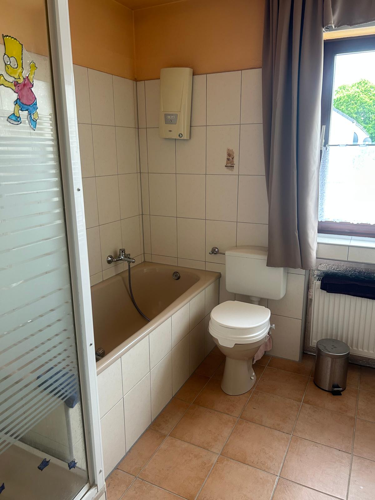 Altes Bad vor der Sanierung: gefliestes Standardbad mit Wanne